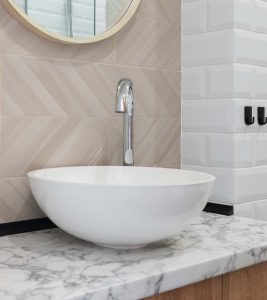 Modern bathroom interior with white stone washbasin and chrome tap