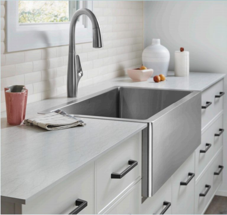 Farmhouse kitchen sink with white countertops and subway tile backsplash