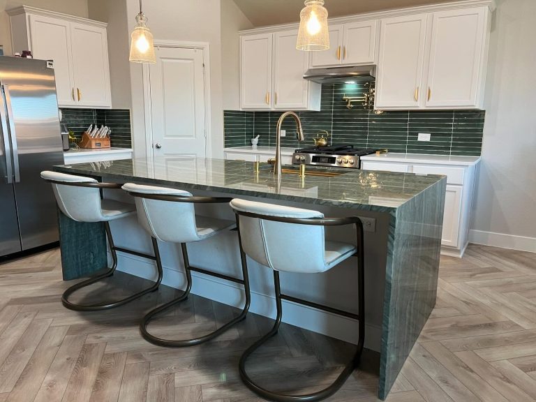 Waterfall stone kitchen island with gold faucet and modern cabinetry